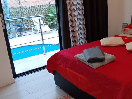 a bedroom with a red bed and a view of a pool at IGGY in Malinska