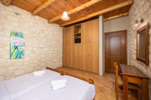 a bedroom with a bed and a desk and a table at Villa Hara Faragi in Giannoudi