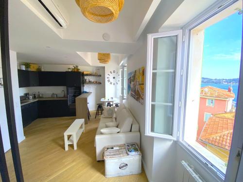 un salon avec un canapé blanc et une grande fenêtre dans l'établissement PEARL AP4444 By Riviera Holiday Homes, à Villefranche-sur-Mer