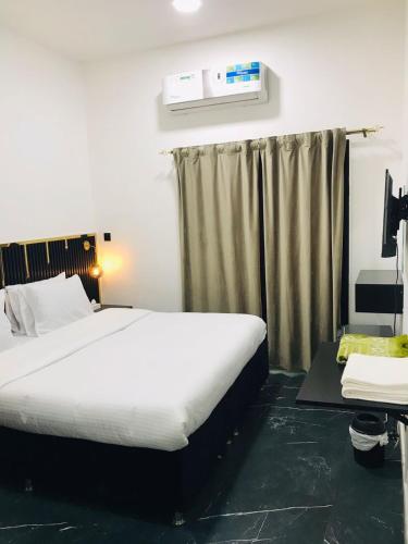 a bedroom with a large bed and a window at Zee Hotel in Dubai