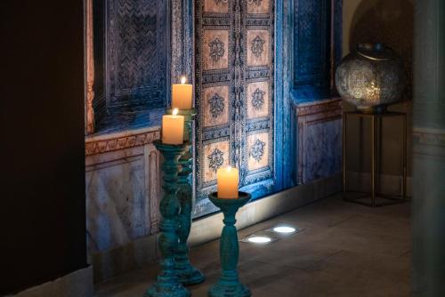 two candles in front of a room with a wall at Il Gentiluomo Hotel & SPA in Arezzo