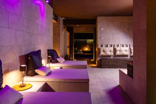 two beds in a room with purple lighting at Il Gentiluomo Hotel & SPA in Arezzo