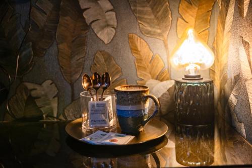a table with a lamp and a coffee cup on it at Il Gentiluomo Hotel & SPA in Arezzo