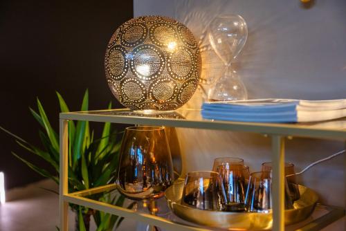 a glass shelf with wine glasses and a ball on it at Il Gentiluomo Hotel & SPA in Arezzo