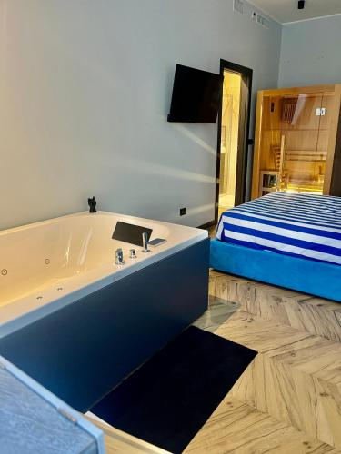 a bath tub in a room with a bed at Penelope's Suite&Spa con parcheggio privato in Como