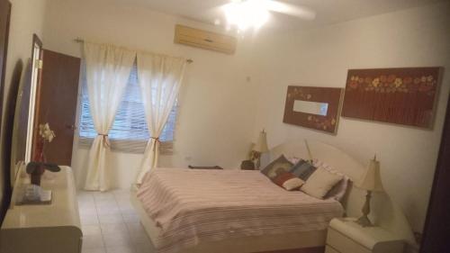 a small bedroom with a bed and a window at Tranquila Oasis in Runaway Bay
