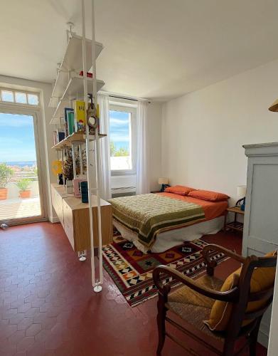 une chambre avec un lit, une table et une fenêtre dans l'établissement Charmant studio-terrasse vue mer, à Marseille