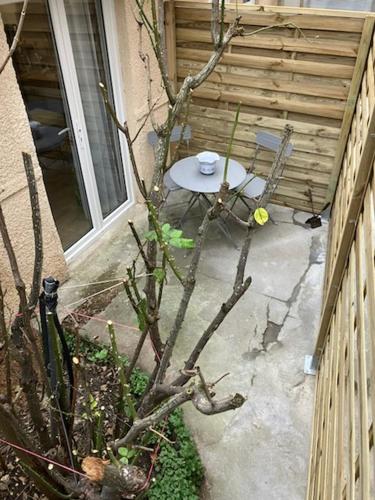 un patio avec une table et une chaise à côté d'un bâtiment dans l'établissement Studio avec terrasse Paris Sud, à Villejuif