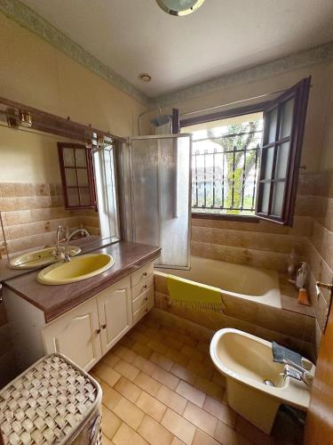 La salle de bains est pourvue d'un lavabo, d'une baignoire et de toilettes. dans l'établissement Villa 4 pièces, 3 chambres, grand terrain paysagé, à Gujan-Mestras