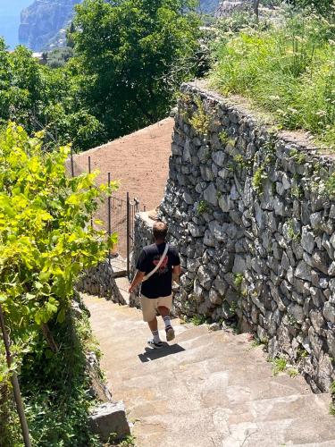 a man walking down a stone wall at Colle dell'Ara in Positano