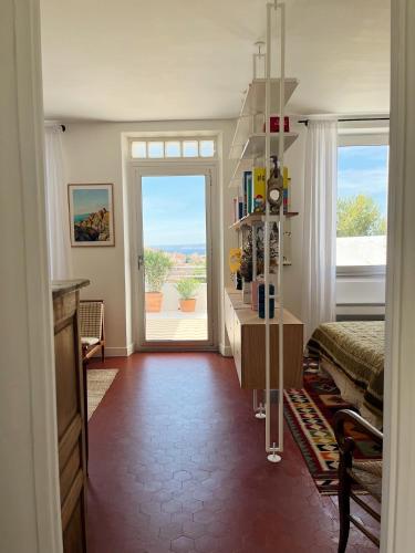 - un salon avec vue sur une chambre dotée d'une porte dans l'établissement Charmant studio-terrasse vue mer, à Marseille