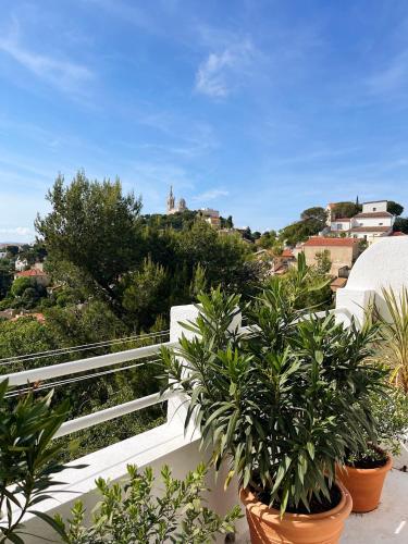 d'un balcon avec des plantes en pot et une vue sur la ville. dans l'établissement Charmant studio-terrasse vue mer, à Marseille