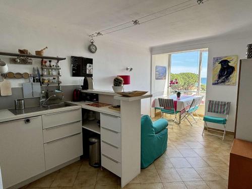- une cuisine avec un évier et un comptoir avec une table dans l'établissement Appartement deux pièces cabine - Argelès sur mer AR360-114, à Argelès-sur-Mer