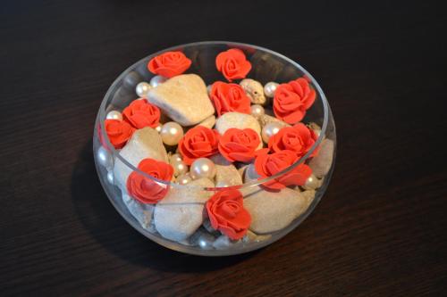 a glass bowl filled with red roses and cookies at Maluma in Izola