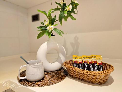 a table with two baskets and a vase and a mug at Loft Suite Central City 2BR JB CIQ 7Pax in Johor Bahru