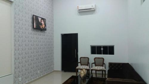 a living room with two chairs and a black door at Big Hotel in Imperatriz