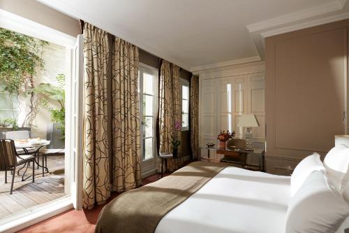 Postel nebo postele na pokoji v ubytování Le Burgundy Paris