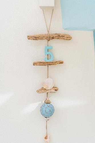 a wooden shelf with a sign on a wall at Oasi Blu Sardinia in Santa Margherita di Pula
