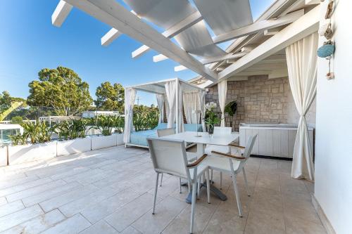 an outdoor patio with a white table and chairs at Oasi Blu Sardinia in Santa Margherita di Pula