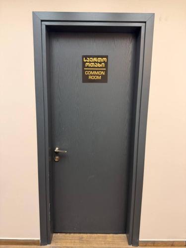 a black door with a sign on it at Gоderdzi Twins Hostel in Khulo