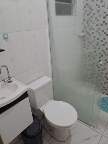 a white bathroom with a toilet and a shower at Casa Grande na zona sul in Sao Paulo