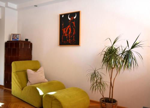 a living room with a green chair and a plant at Maluma in Izola
