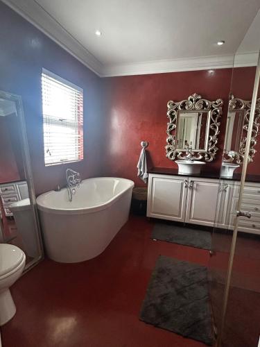 a bathroom with a white tub and a mirror at Harbour Town 12 Sleeper in Vaal Marina