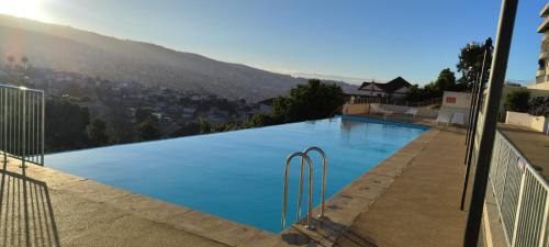 a large swimming pool with a view of a city at Ocean View & Pool Family Apartment 1P in Valparaíso