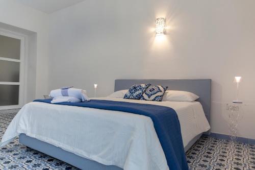 a bedroom with a large bed with blue and white sheets at Le Due Sorelle in Vietri sul Mare