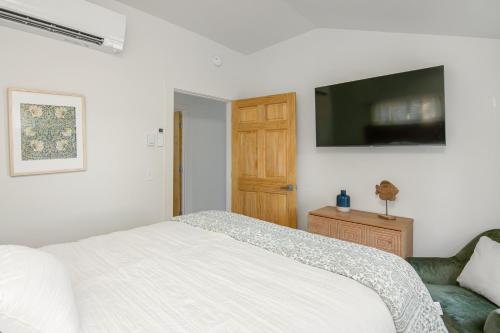 a bedroom with a bed and a television on the wall at Lakeshore Vermont in Colchester