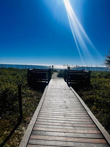 a wooden boardwalk leading to the beach on a clear day at Boardwalk Beach Resort in Myrtle Beach