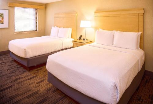 a hotel room with two beds with white pillows at LivINN Hotel Cincinnati North/ Sharonville in Sharonville