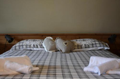 a bed with two pillows and towels on it at Monica's apartment Mansarda - Stella Alpina in Sauze dʼOulx