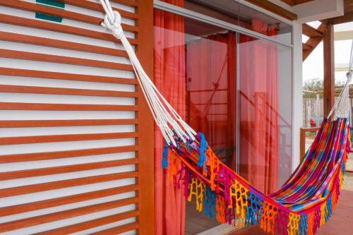 a hammock hanging on the side of a house at Mangata in Lobitos