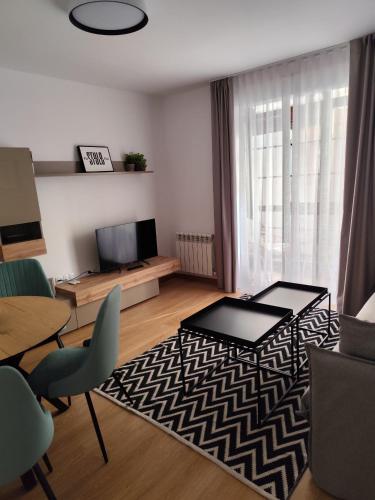 a living room with a television and a table and chairs at Apartamentos Turisticos de Soria Collado 3 in Soria