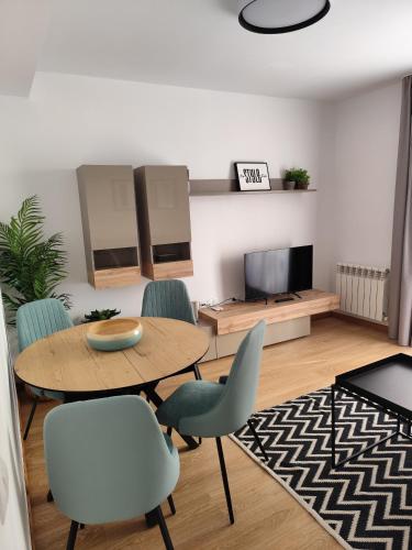 a living room with a table and chairs and a tv at Apartamentos Turisticos de Soria Collado 3 in Soria