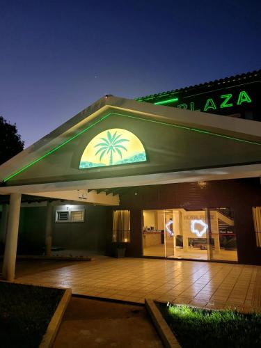 a building with a sign with a palm tree on it at Fênix Plaza Hotel in Aquidauana