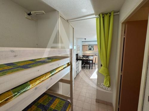 - une chambre avec 2 lits superposés et une salle à manger dans l'établissement rez de jardin residence en bord de mer piscine tennis stationnement, à Sète