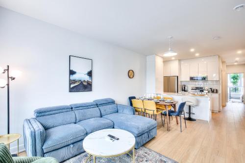 a living room with a blue couch and a kitchen at Beautiful & New! Renovated for your Style Comfort in Montréal