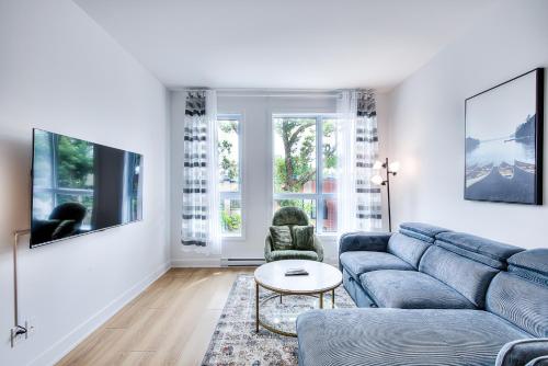 a living room with a blue couch and a table at Beautiful & New! Renovated for your Style Comfort in Montréal