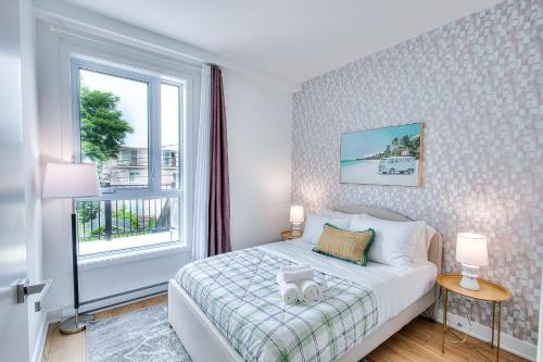 a bedroom with a bed and a window at Beautiful & New! Renovated for your Style Comfort in Montréal