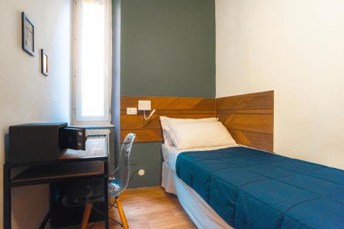 a bedroom with a bed and a desk and a television at I Mecenati in Macerata