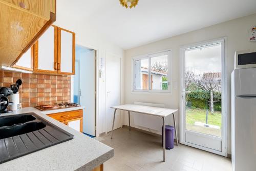 une cuisine avec un évier et une table à l'intérieur dans l'établissement 51 - Entre Plage et Vieux Port, à Pornic