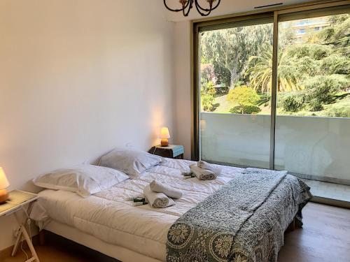 une chambre avec un lit et une grande fenêtre dans l'établissement Bord de mer, terrasse vue mer 228L, à Cannes