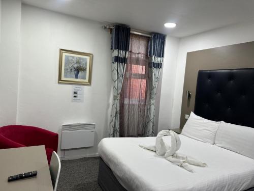a hotel room with a bed and a red chair at Abbey Hotel in Leicester