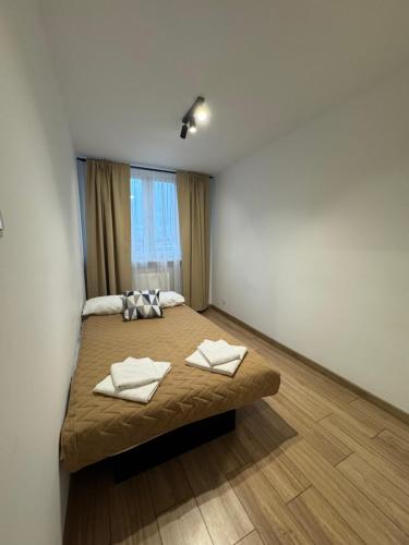 a bedroom with a bed with two towels on it at Apartament Powstańców 19 in Oświęcim