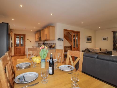 a dining room and kitchen with a table and a couch at Bruach Gorm Cottage in Grantown on Spey