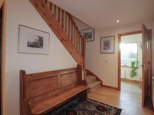 a staircase in a home with a wooden stair case at Bruach Gorm Cottage in Grantown on Spey