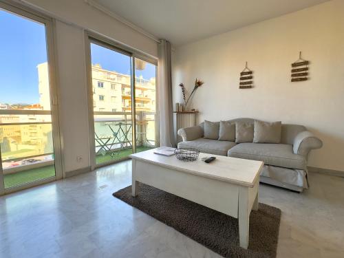 un salon avec un canapé et une table basse dans l'établissement L'Alexandra By SCLS Locations, à Cannes