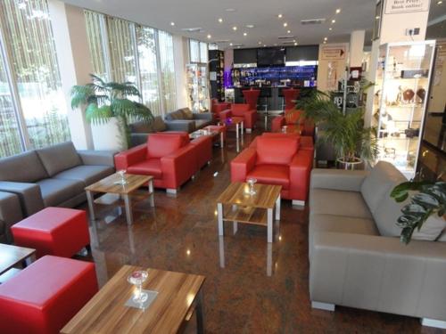 a store with couches and red chairs and tables at Grand Hotel Dream Main City Center in Frankfurt